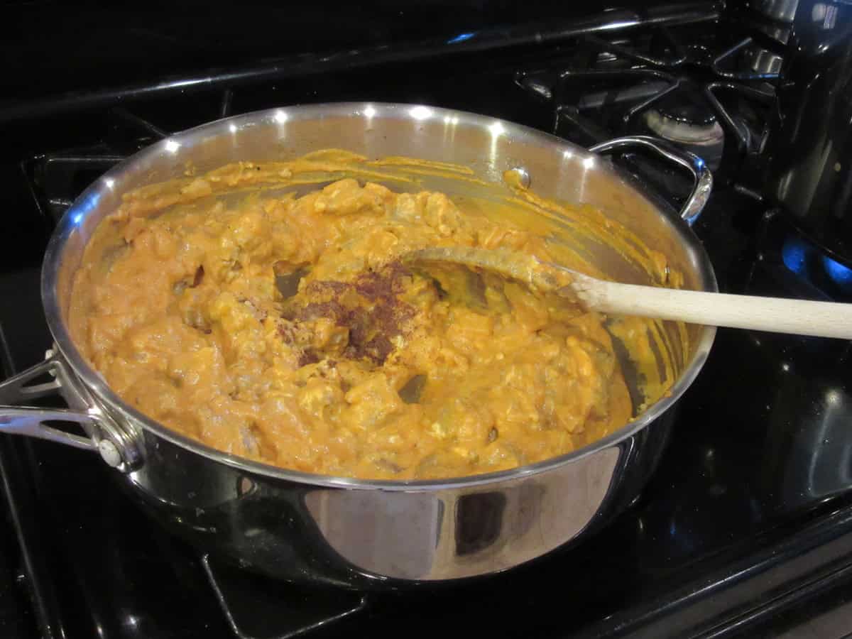 A creamy pasta sauce with cream cheese and nutmeg in a pan.