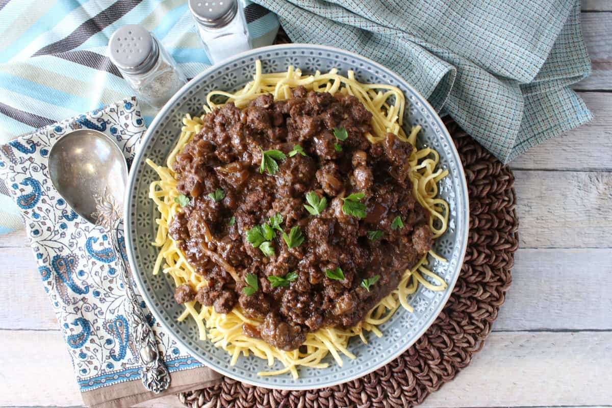 Rich ground beef and gravy over a plate of noodles.