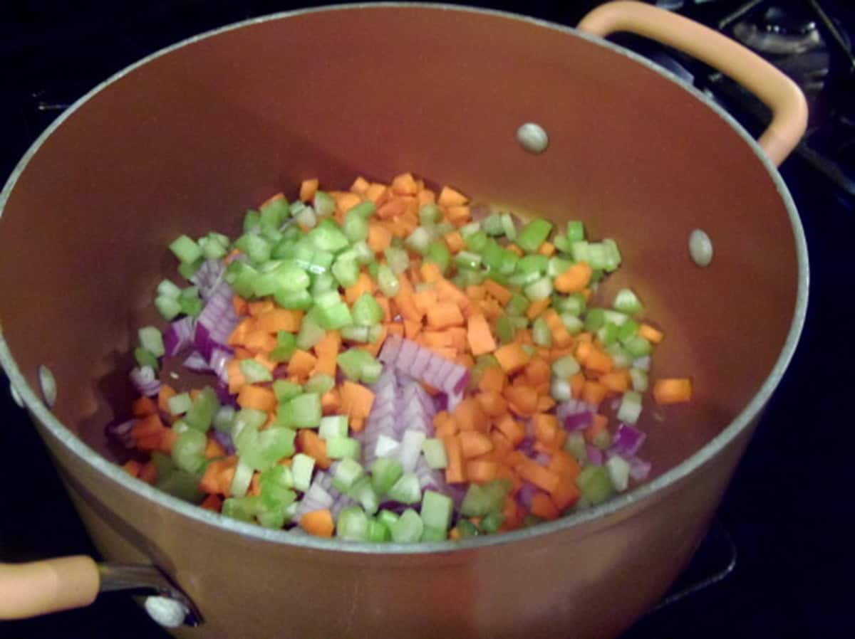 Diced onions, carrots, and celery in a soup pot before cooking.