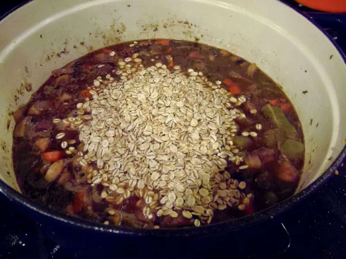 Quick cooking barley in a Dutch oven with beef cubes and broth.