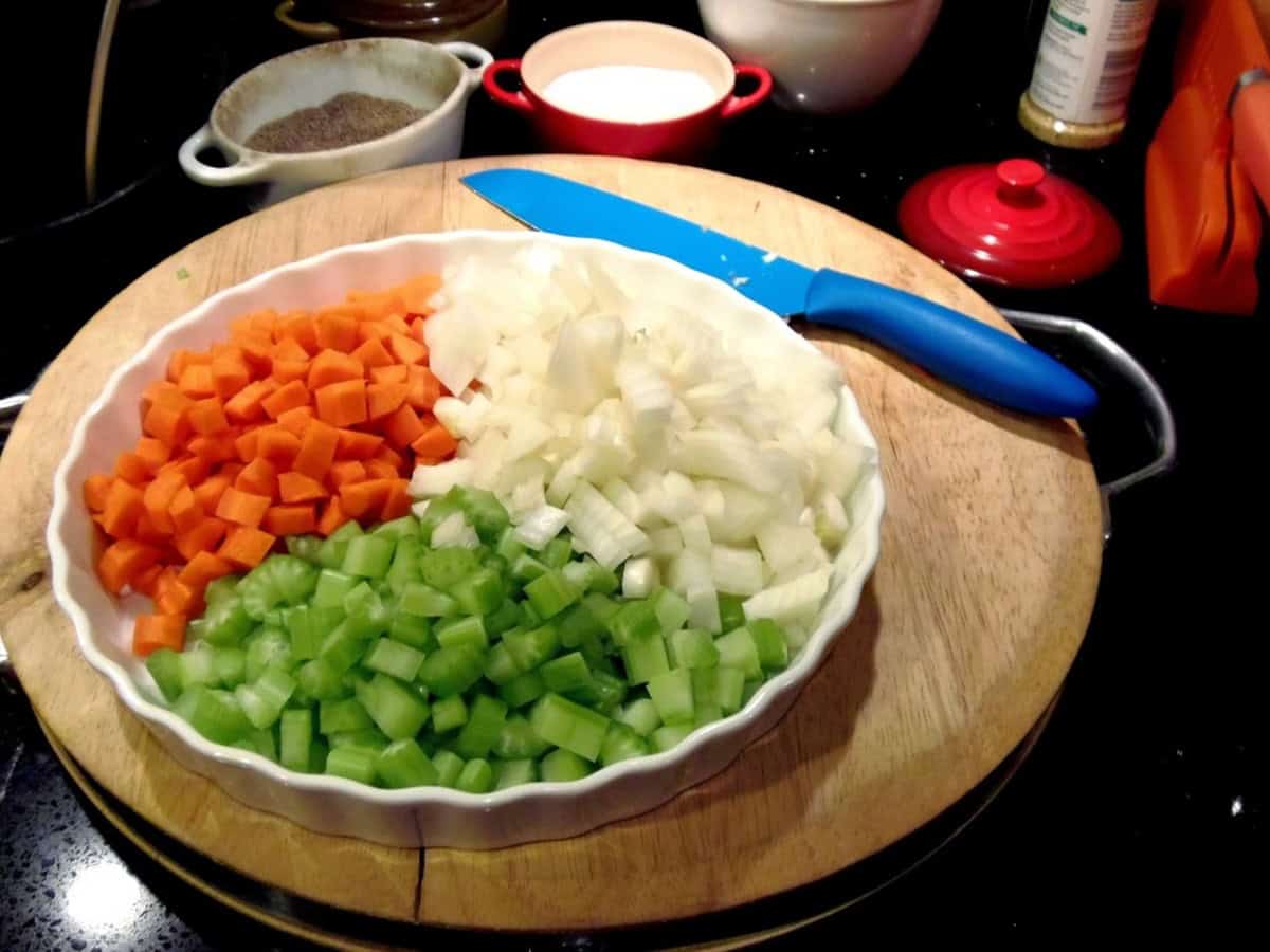 Diced carrots, celery and onions in a dish for making beef and barley stew.