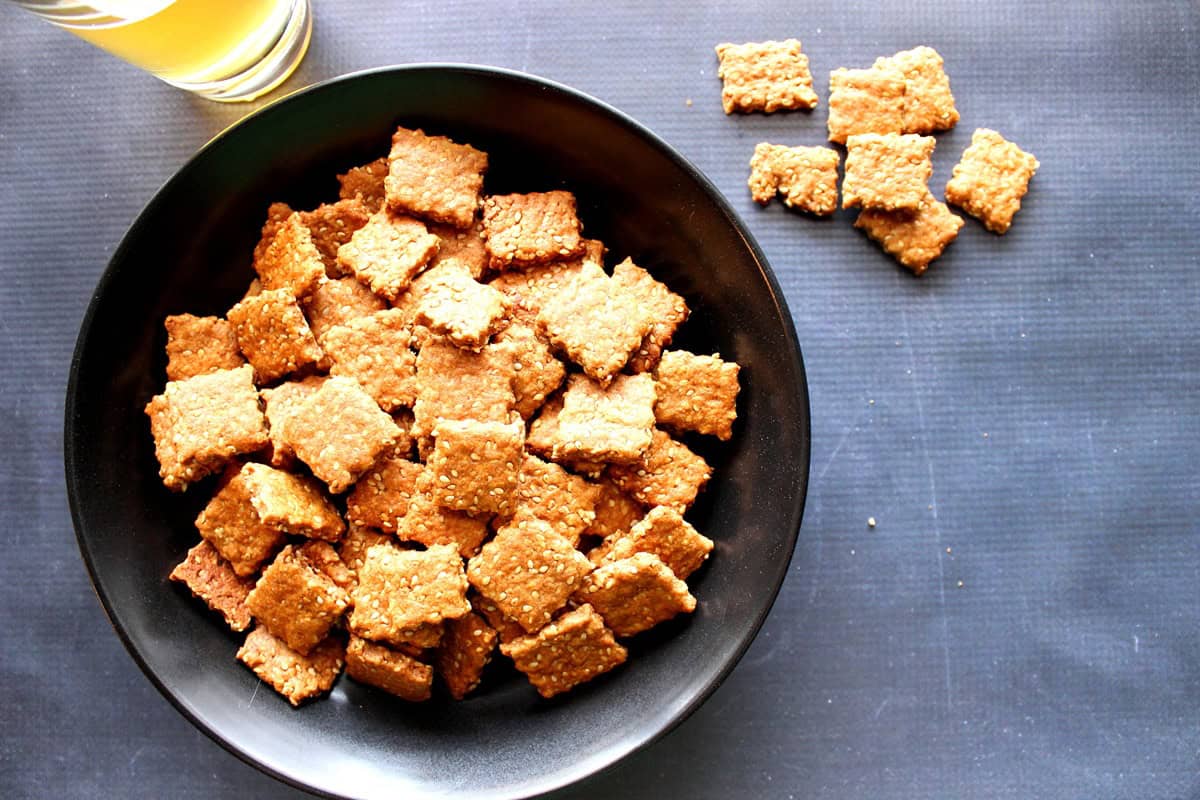 A black table covering and a bowl setup for homemade sesame seed crackers.