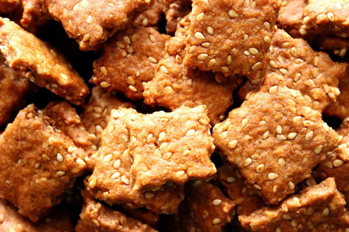 A close look at homemade sesame seed crackers with wavy edges.