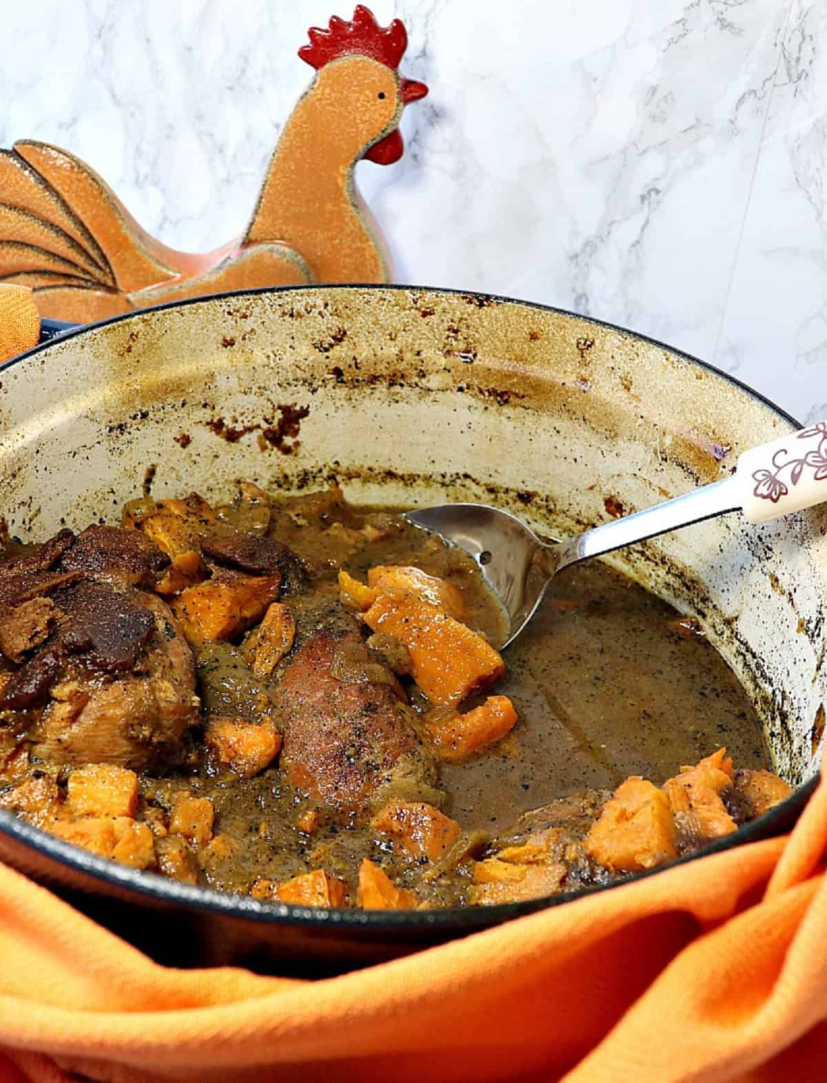 Apple Cider Braised Chicken Breasts with Sweet Potatoes & Gingersnaps - kudoskitchenbyrenee.com A Dutch oven with braised apple cider chicken and sweet potatoes inside.