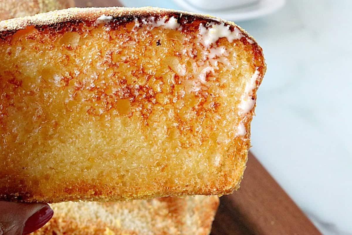 Melted butter on a slice of lightly toasted English muffin bread.