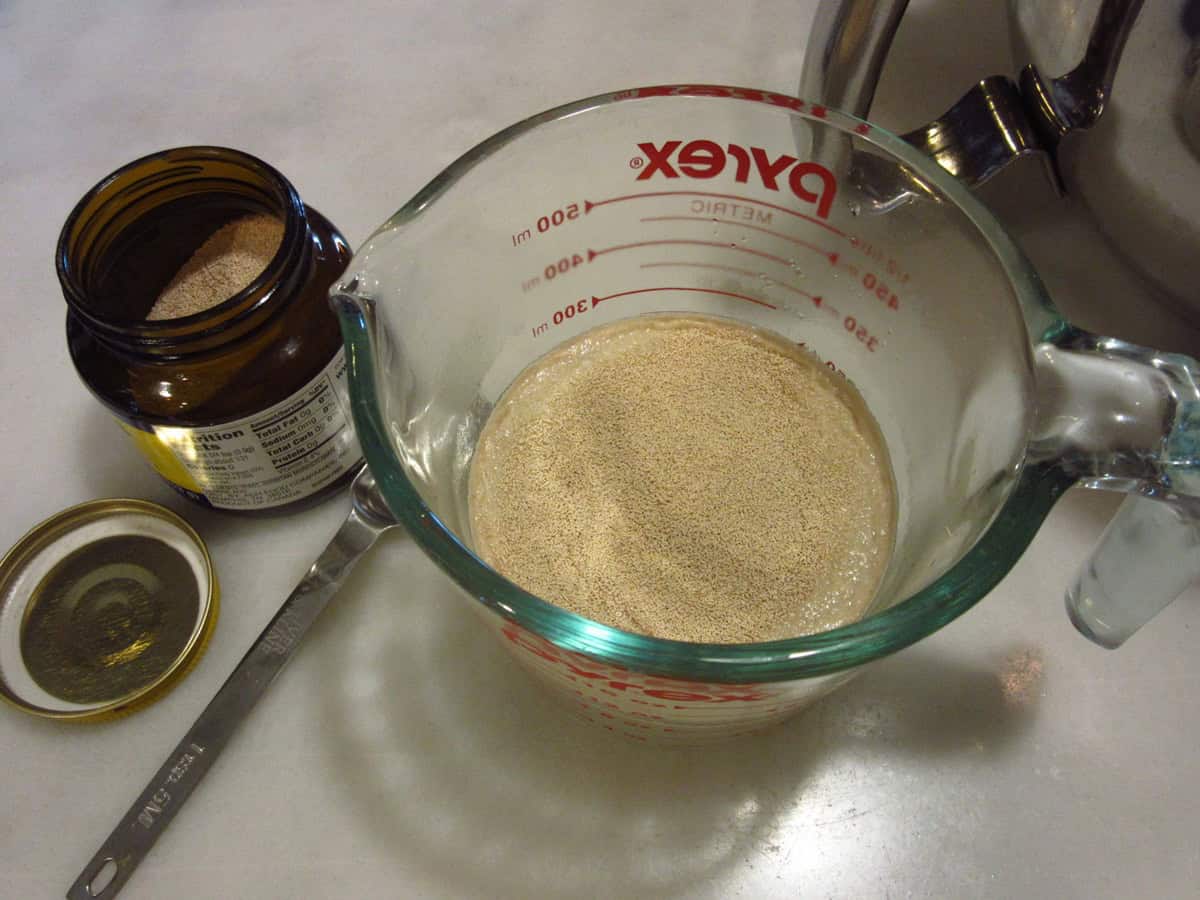Active dry yeast in a glass measuring cup with water.