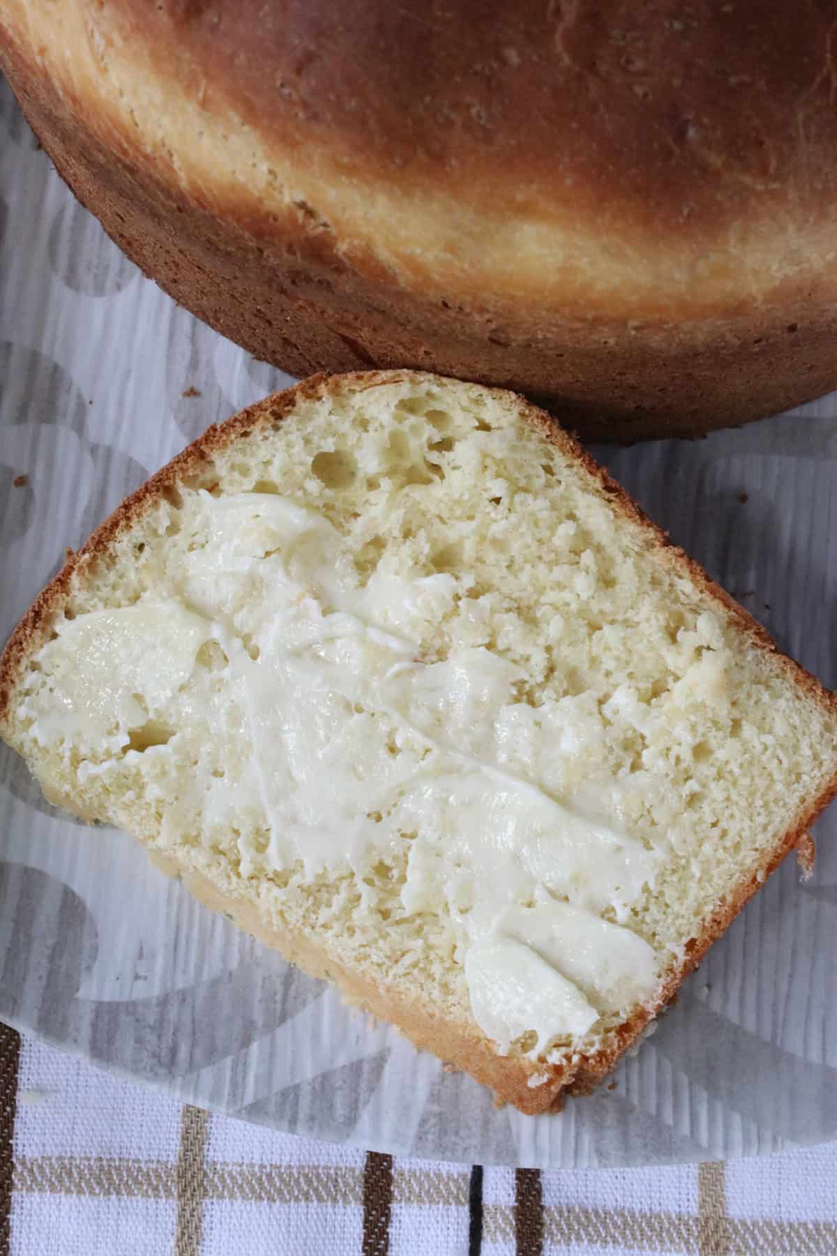 A buttered slice of Sally Lunn bread on a plate.