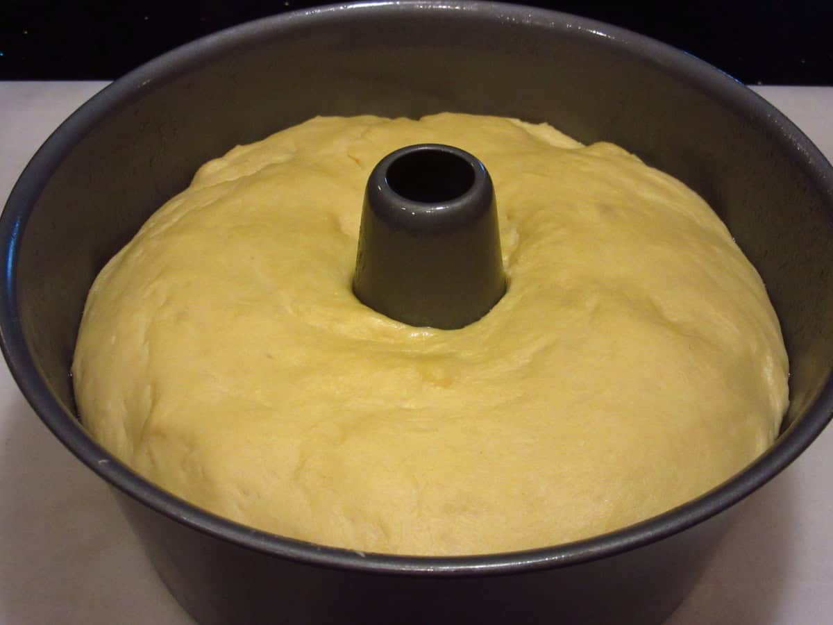 A soft enriched dough in a tube pan after a second proof and before baking.