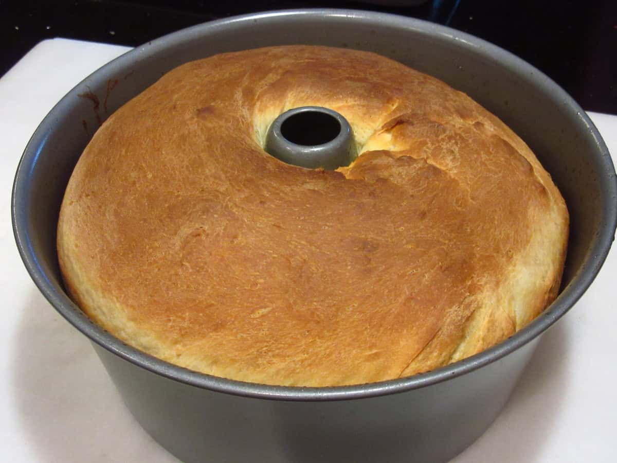 A golden brown loaf of Sally Lunn batter bread after baking and still in the tube pan.