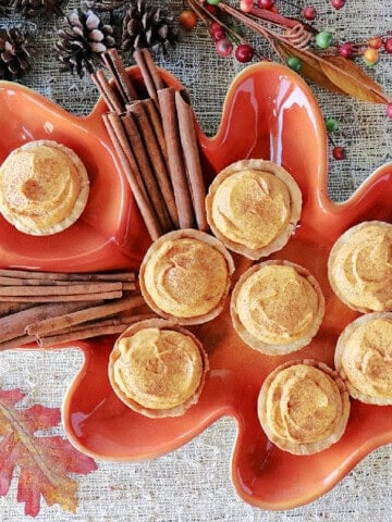 An orange leaf tray filled with pumpkin cheesecake filled cookie cups.